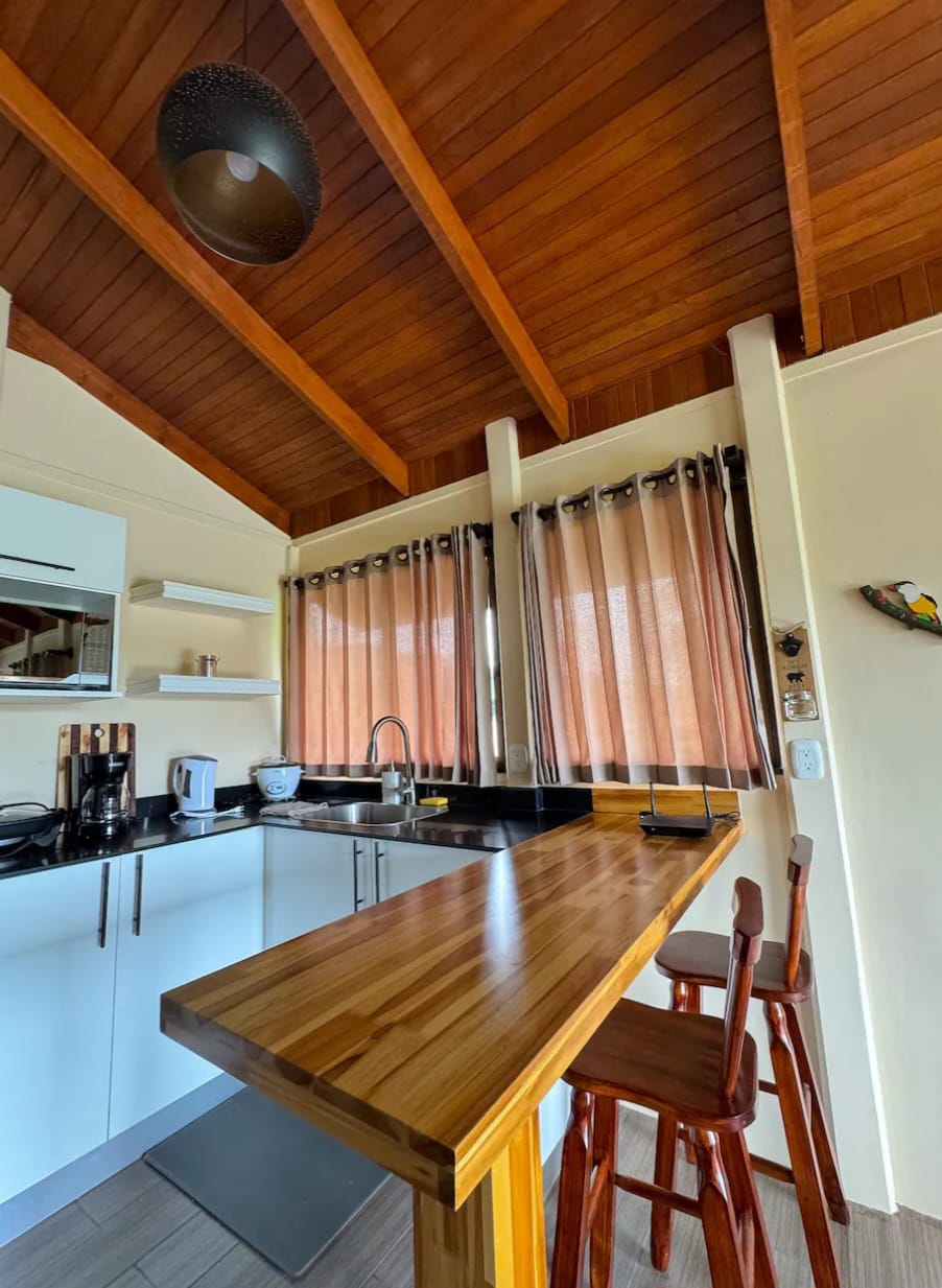 Teak breakfast bar with stools under a vaulted wooden ceiling